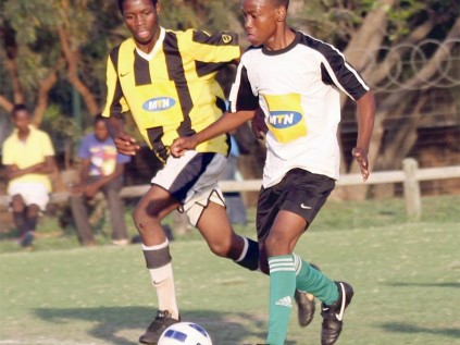 Dinho FC's Lefa Thobejane controls the ball while Matodzi Sadiki of Hwelereng Young Stars Academy prepares to intercept.