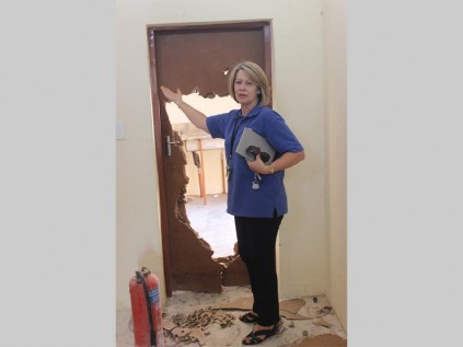 Desiree van der Walt (DA shadow deputy minister of education) at a door that has been smashed. The door is part of the new school building of Setotolwane Secondary School in Mankweng, which has not yet been occupied.