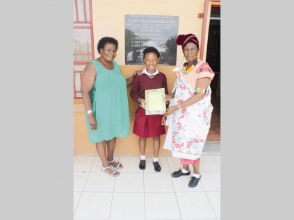 Emelia Legodi (Phishego Primary School, teacher) and Mmaditsela Sebotja (Phishego Primary School, principal) present a certificate of excellence in mathematics and English to Letago Morata, a gr. 7 learner.