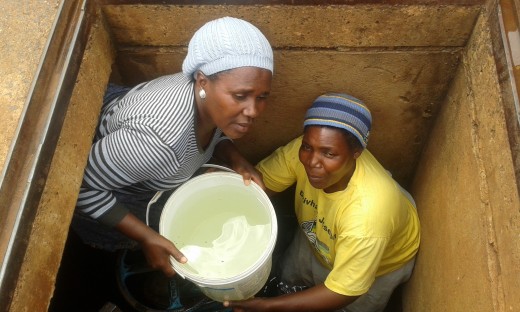 Two women struggle to get a bucket of water out of a manhole that villagers broke into to get clean water in Dopeni village near Louis Trichardt.